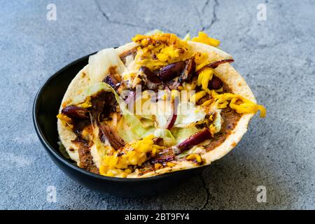 Taco Cig Kofte im türkischen mexikanischen Stil mit Kidney Beans, roten Zwiebeln, geriebenem Cheddar-Käse und Granatapfelsauce. Traditionelles Fast Food. Stockfoto