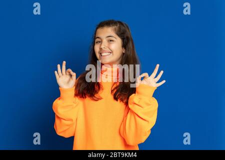 Liebenswert preteen Mädchen mit gelben Jersey auf einem blauen Hintergrund Stockfoto