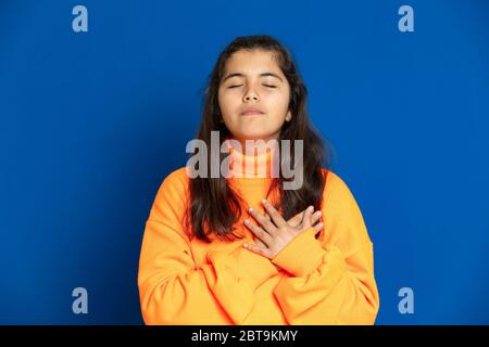 Liebenswert preteen Mädchen mit gelben Jersey auf einem blauen Hintergrund Stockfoto