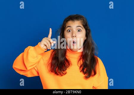 Liebenswert preteen Mädchen mit gelben Jersey auf einem blauen Hintergrund Stockfoto