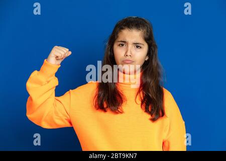 Liebenswert preteen Mädchen mit gelben Jersey auf einem blauen Hintergrund Stockfoto