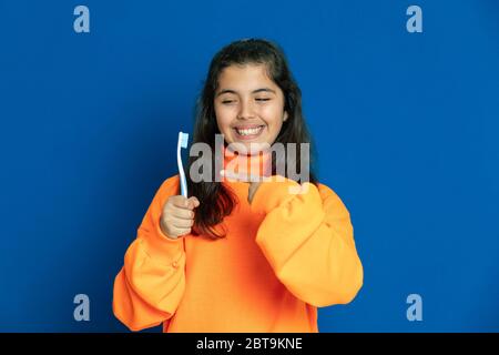 Liebenswert preteen Mädchen mit gelben Jersey auf einem blauen Hintergrund Stockfoto