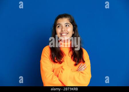 Liebenswert preteen Mädchen mit gelben Jersey auf einem blauen Hintergrund Stockfoto