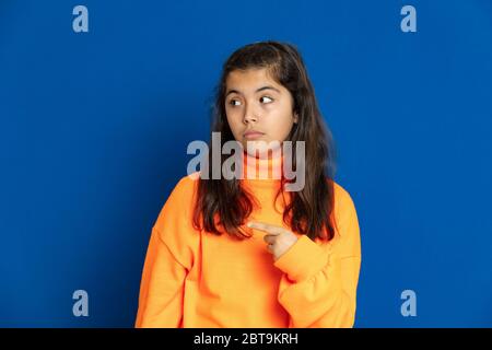 Liebenswert preteen Mädchen mit gelben Jersey auf einem blauen Hintergrund Stockfoto