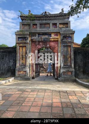 Frau, die durch einen alten Bogen am Imperial Minh Mang Grab in Hue, Vietnam, Imperial City Stockfoto