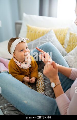 Junge Mutter spielt mit ihrem Baby zu Hause Stockfoto