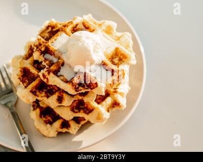 Ricotta Käse schabt für Keto Ernährung. Stapel von Ricotta und Zitrone belgische Waffeln mit Eis Schaufel dekoriert.Copy Raum für Text oder Design. Natürlicher Sonnenuntergang oder Sonnenaufgang Tageslicht. Draufsicht oder flaches Lay Stockfoto