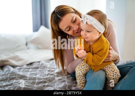 Glückliche liebevolle Familie. Mutter und Kind Mädchen spielen, küssen und umarmen Stockfoto
