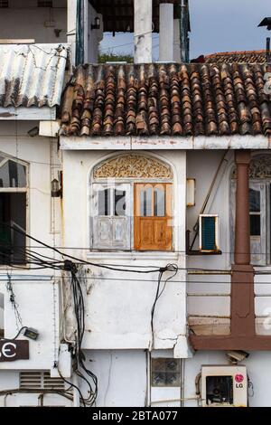 Ein Fenster neben einem Balkon in einem der alten Gebäude in Galle Fort, umgeben von elektrischen Kabeln. Stockfoto