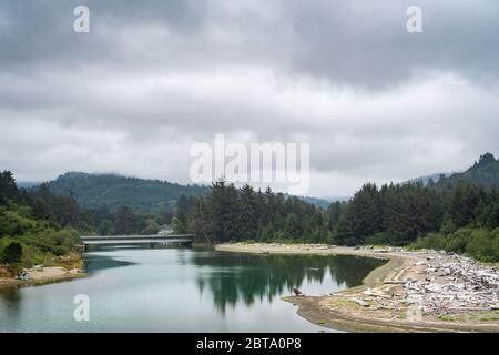 Ein ruhiger Fluss an der Westküste von Oregon, USA an einem bewölkten, bewölkten Tag. Stockfoto