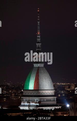 Turin, Italien - 31. März 2020: Die Mole Antonelliana, ein wichtiges Wahrzeichen von Turin, wird mit den Farben der italienischen Nationalflagge beleuchtet, um Solidarität, Zusammenhalt und Heimatgefühl während der COVID-19-Notlage auszudrücken. Die italienische Regierung hat beispiellose Beschränkungen auferlegt, um die Ausbreitung des COVID-19-Coronavirus-Ausbruchs zu stoppen, unter anderem dürfen Menschen nur zur Arbeit, zum Kauf wesentlicher Güter und aus gesundheitlichen Gründen verlagern. Quelle: Nicolò Campo/Alamy Live News Stockfoto