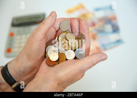 Eine ältere Frau hält viele verschiedene Münzen in ihren Händen. Finanzkonzept Stockfoto