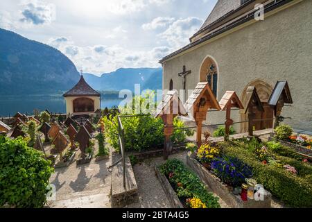 Gräber mit Blick auf den Hallstätter See auf dem Friedhof rund um die römisch-katholische Pfarrkirche Hallstatt, Salzkammergut, OÖ, Österreich Stockfoto