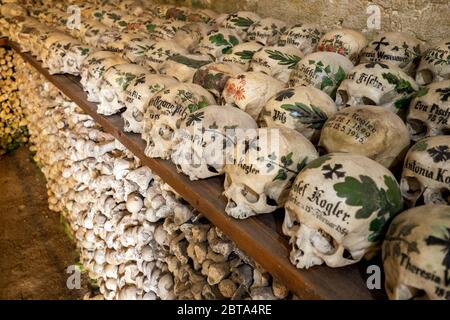 Blick auf Hunderte von bemalten Schädeln und Knochen im berühmten Holzhaus im Bergdorf Hallstatt im Salzkammergut, Österreich Stockfoto