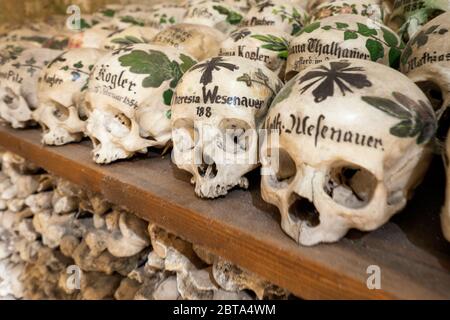 Blick auf Hunderte von bemalten Schädeln und Knochen im berühmten Holzhaus im Bergdorf Hallstatt im Salzkammergut, Österreich Stockfoto