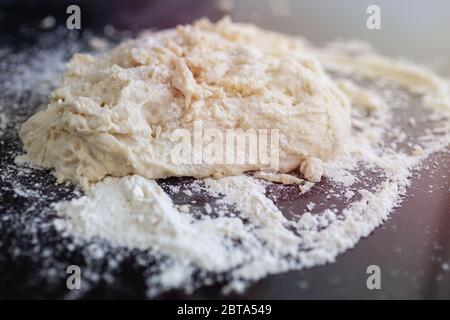 Nahaufnahme Hintergrund von gekneteten Teig für Brot, Pasta oder Pizza auf schwarzem Tisch Stockfoto