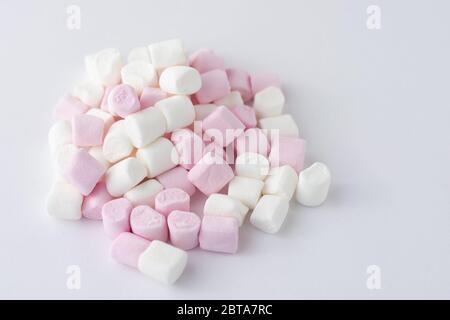 Rosa und weiße Marshmallows auf weißem Hintergrund von der Seite gesehen Stockfoto