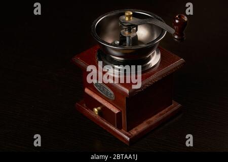 Manuelle Kaffeemühle zum Mahlen von Kaffeebohnen. Schwarzer Hintergrund. Vintage Kaffeemühle Stockfoto