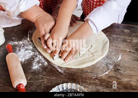 Glückliche Familie Mutter und kleine Tochter machen Kekse und Spaß in der Küche. Stockfoto