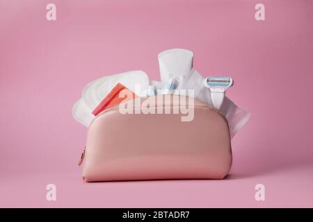 Hygiene feminine Pads, Tampon und Rasiermesser in der Kosmetiktasche auf rosa Hintergrund. Menstruationszyklus. Pflege der Gesundheit von Frauen. Stockfoto