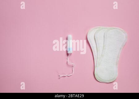 Weiße Damenunterlage aus Baumwolle und femininer Tampon auf rosa Hintergrund, Draufsicht. Feminine Hygieneprodukte Stockfoto