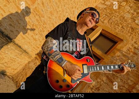 CHARNAY, FRANKREICH, 5. Juli 2019 : ein Amateur-Lead-Gitarrist posiert auf dem Dorfplatz. Stockfoto