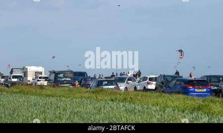 Worthing UK 24. Mai 2020 - Stau am Meer, da Besucher und Kitesurfer das windige, aber sonnige Wetter in Goring Gap in der Nähe von Worthing in West Sussex genießen dieses Feiertagswochenende während der Coronavirus COVID-19 Pandemie . : Credit Simon Dack / Alamy Live News Stockfoto