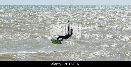 Worthing UK 24. Mai 2020 - Kite Surfer genießen das windige, aber sonnige Wetter in Goring by Sea bei Worthing in West Sussex an diesem Feiertagswochenende während der COVID-19 Pandemie. : Credit Simon Dack / Alamy Live News Stockfoto