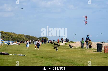 Worthing UK 24. Mai 2020 - Besucher und Kitesurfer genießen das windige, aber sonnige Wetter in Goring by Sea bei Worthing in West Sussex an diesem Feiertagswochenende während der COVID-19 Pandemie. : Credit Simon Dack / Alamy Live News Stockfoto