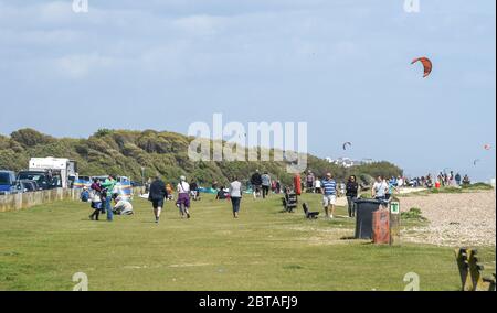 Worthing UK 24. Mai 2020 - Besucher und Kitesurfer genießen das windige, aber sonnige Wetter in Goring by Sea bei Worthing in West Sussex an diesem Feiertagswochenende während der COVID-19 Pandemie. : Credit Simon Dack / Alamy Live News Stockfoto