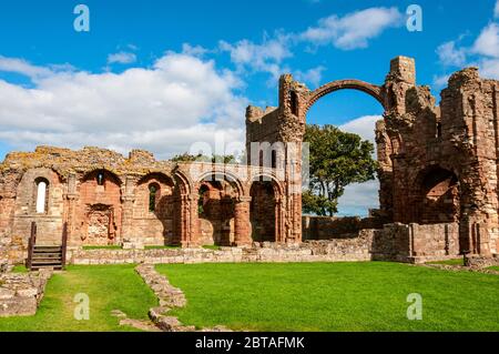 Helles Sonnenlicht wird von den Wänden des östlichen Endes der Kirche von Lindisfarne Priory reflektiert, die das Querschiff, den Chor und das Presbyterium umschließt Stockfoto