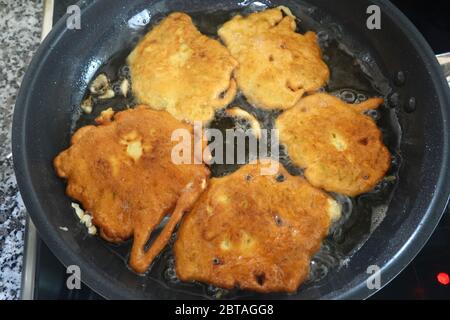 Holunderblüten in Pfannkuchen Teig immer in der Pfanne, aus der Nähe von Hollerkrapfen traditionelle europäische Sommer süß Holunder schwarz, sambucus nigra l. Stockfoto