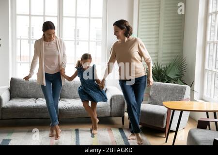 Energiegeladen drei Generationen von Frauen tanzen zu Hause Stockfoto