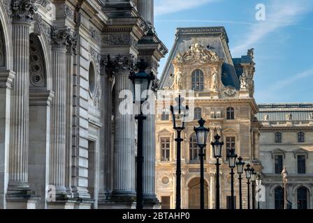 Morgenansicht des Louvre Museums mit Straßenlaternen und blauem Himmel in Paris, Frankreich. Stockfoto