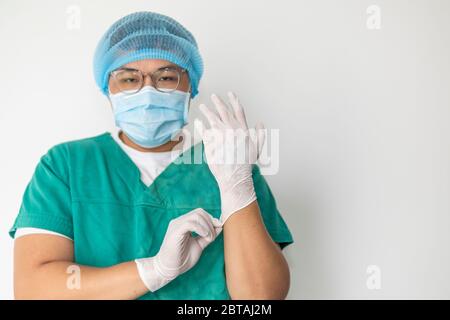 Arzt zieht Handschuhe an und trägt medizinische Maske. Medical, covid-19, Corona Virus, Krankenhauskonzept Stockfoto