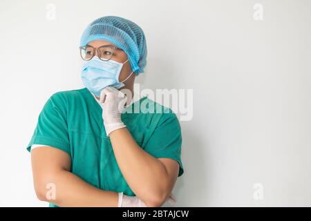 Junger männlicher Arzt. Denkender Arzt. Gesicht in einer medizinischen Maske Nahaufnahme. Gedanken darüber, wie Sie sich und Patienten schützen. Cleverer Mediziner. Ein verblüffter Blick. As Stockfoto