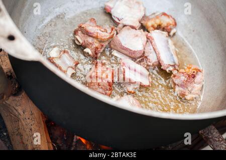 Lammfleisch auf Knochen in einem Kessel eintoben. Vorbereitung der Chorba-Suppe auf offenem Feuer, traditionelle Mahlzeit für viele nationale Küche Stockfoto