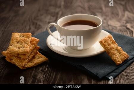 Mehrere Kekse und eine Tasse Tee auf einem Holztisch. Stockfoto