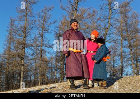 KHATGAL, MONGOLEI, 2. März 2020 : Mongolische Menschen, in traditioneller Kleidung gekleidet, posieren in einer Waldlandschaft. Stockfoto