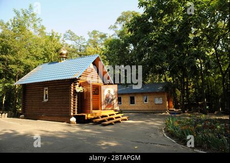 Eine alte orthodoxe Holzkirche, die in einem Park gebaut wurde, die Türen weit geöffnet. Babi Jar, Kiew, Ukraine Stockfoto