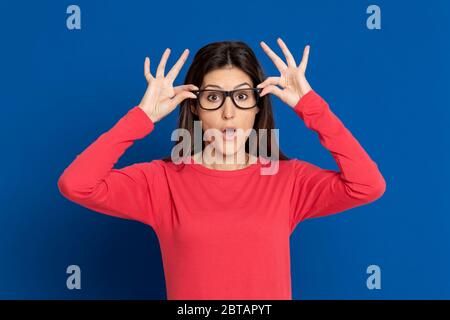 Attraktive Brünette Mädchen trägt ein rotes T-Shirt auf blauem Hintergrund Stockfoto