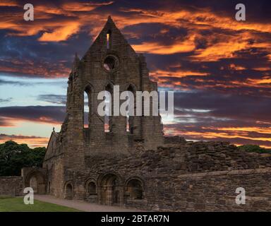 Das alte Querschiff von Kilwinning Abey in Schottland ist nun in Ruinen und mit einem dramatischen Sonnenuntergang. Stockfoto