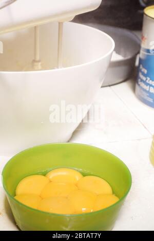 Einen Kuchen mit Eigelb, Mehl, Teig, Schokoladenpulver, Mischen mit einem Mixer in einer Schüssel Stockfoto