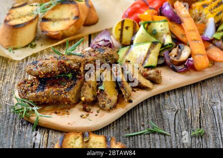 Gegrillte vegane Seitan Steaks mit gemischtem Gemüse und knusprigem Baguette Stockfoto