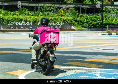 Kurier eines beliebten Lebensmittel-Lieferservice in Malaysia auf einem Fahrrad. Essen bestellen zu Hause. Stockfoto