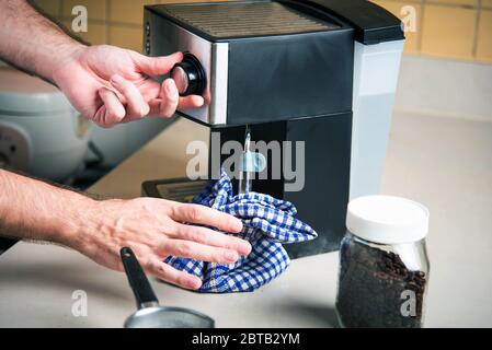 Person, die Milchaufschäumer für die Espressomaschine zum Kaffeekochen verwendet. Lifestyle-Konzept für den Barista im Haus Stockfoto