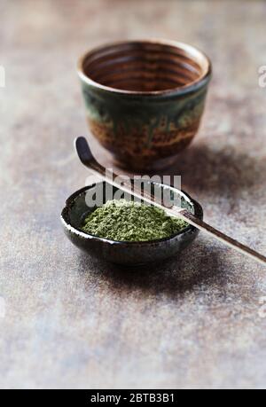 Pulverisierter Matcha grüner Tee auf rustikalem Stein Hintergrund. Stockfoto