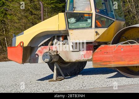 Straßenwalze mit einem gebrochenen Rad. Straßenwalze Verdichter auf Autobahn, diese verwendet, um kompakte Kies, Beton oder Boden im Straßenbau, Stockfoto