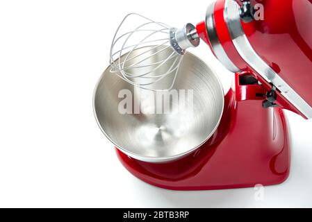 Stilvoller Roter Küchenmischer Mit Isoliertem Schnittpfad Auf Weißem Hintergrund. Professioneller elektrischer Stahl-Mixer mit Metallbesen Stockfoto