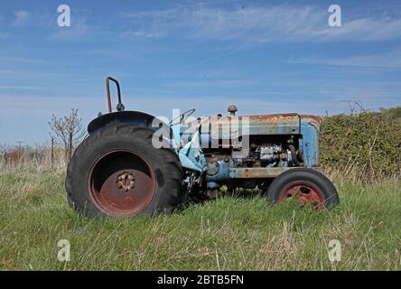 Alte Traktor im Küstenfeld aufgegeben Eccles-on-Sea, Norfolk, Großbritannien, Europa April Stockfoto